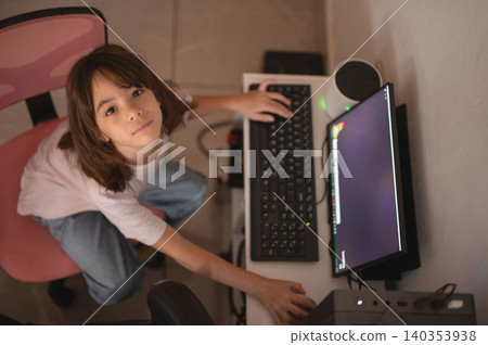 Child works on computer at home desk during the afternoon Child works on computer at home desk during the afternoon 140353938