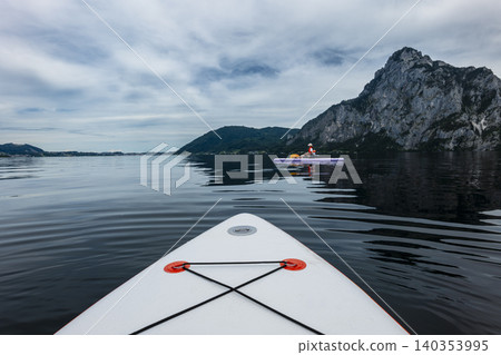Stand up paddleboards floating on lake Traunsee in the Austrian Alps, capturing a summer recreational moment and a burst of energy Stand up paddleboards floating on lake Traunsee in the Austrian Alps, capturing a summer recreational moment and a burst of energy 140353995