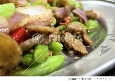 Savory beef stir fry featuring sliced vegetables and red chili accents arranged on a plate for serving Savory beef stir fry featuring sliced vegetables and red chili accents arranged on a plate for serving 140354048