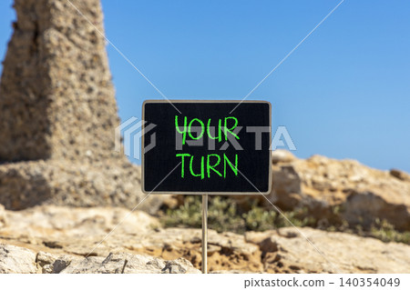 Your turn words symbol. Concept words Your turn on beautiful black blackboard. Beautiful stone and blue sky background. Business your turn motivational support concept. Copy space. Your turn words symbol. Concept words Your turn on beautiful black blackboard. Beautiful stone and blue sky background. Business your turn motivational support concept. Copy space. 140354049