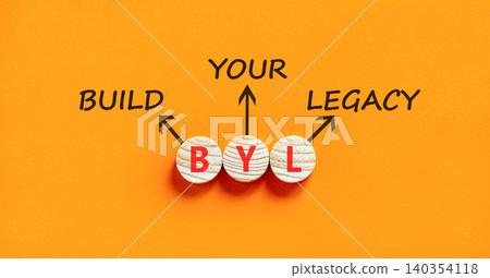 BYL build your legacy symbol. Concept words BYL build your legacy on beautiful wooden circles. Beautiful orange background. Business BYL build your legacy concept. Copy space 140354118