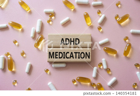 ADHD medication symbol. Concept word ADHD medication on wooden blocks. Beautiful pink background with pills. Medicine and ADHD medication. Copy space ADHD medication symbol. Concept word ADHD medication on wooden blocks. Beautiful pink background with pills. Medicine and ADHD medication. Copy space 140354181
