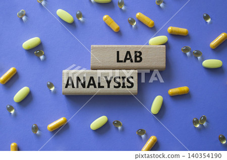 LAB ANALYSIS symbol. Concept word LAB ANALYSIS on wooden blocks. Beautiful purple background with pills. Medicine and LAB ANALYSIS. Copy space 140354190