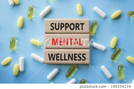 Support Mental Wellness symbol. Concept words Support Mental Wellness on wooden blocks. Beautiful blue background with pills. Healthcare and Support Mental Wellness concept. Copy space. Support Mental Wellness symbol. Concept words Support Mental Wellness on wooden blocks. Beautiful blue background with pills. Healthcare and Support Mental Wellness concept. Copy space. 140354239