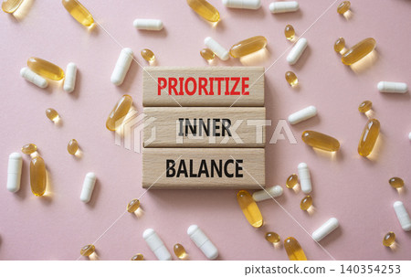 Prioritize inner balance symbol. Concept words Prioritize inner balance on wooden blocks. Beautiful pink background with pills. Healthcare and Prioritize inner balance concept. Copy space. Prioritize inner balance symbol. Concept words Prioritize inner balance on wooden blocks. Beautiful pink background with pills. Healthcare and Prioritize inner balance concept. Copy space. 140354253