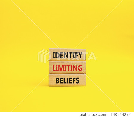 Limiting Beliefs symbol. Concept word Identify Limiting Beliefs on wooden blocks. Beautiful yellow background. Business and Limiting Beliefs concept. Copy space 140354254