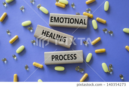Emotional Healing Process symbol. Concept words Emotional Healing Process on wooden blocks. Beautiful purple background with pills. Healthcare and Emotional Healing Process concept. Copy space. 140354273