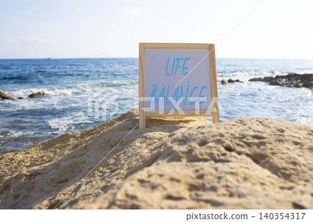 Life Balance symbol. White blackboard with Concept words Life Balance. Beautiful sea background. Business and Life Balance concept. Copy space. Life Balance symbol. White blackboard with Concept words Life Balance. Beautiful sea background. Business and Life Balance concept. Copy space. 140354317