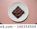 Chocolate brownie on pink table Chocolate brownie on pink table 140354504