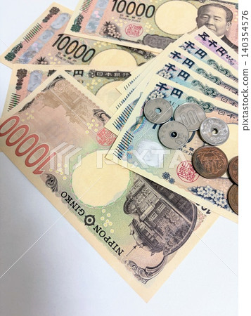 一張展開的10000日元紙幣、一張1000日元紙幣和一些硬幣 140354576