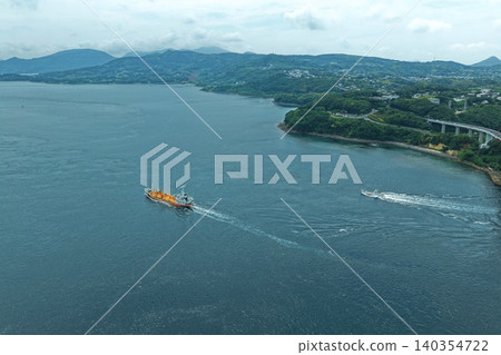 從空中拍攝的照片顯示,一艘貨船和幾艘漁船正在長崎縣平戶市的海峽中航行。 從空中拍攝的照片顯示,一艘貨船和幾艘漁船正在長崎縣平戶市的海峽中航行。 140354722