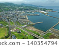 An aerial photograph overlooking Tateura Fishing Port and the port town on Ikitsuki Island in Hirado City, Nagasaki Prefecture. 140354794