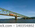 The Limited Express Uzushio train runs across the Yoshinogawa Bridge between Sako Station and Yoshinari Station on the Kotoku Line in Tokushima Prefecture. 140354802