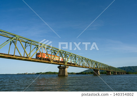 The Limited Express Uzushio train runs across the Yoshinogawa Bridge between Sako Station and Yoshinari Station on the Kotoku Line in Tokushima Prefecture. The Limited Express Uzushio train runs across the Yoshinogawa Bridge between Sako Station and Yoshinari Station on the Kotoku Line in Tokushima Prefecture. 140354802