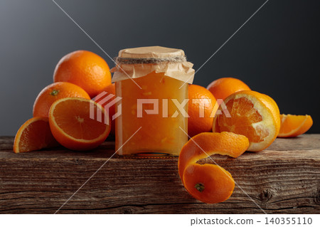Homemade orange jam in a glass jar on on a black background. Homemade orange jam in a glass jar on on a black background. 140355110