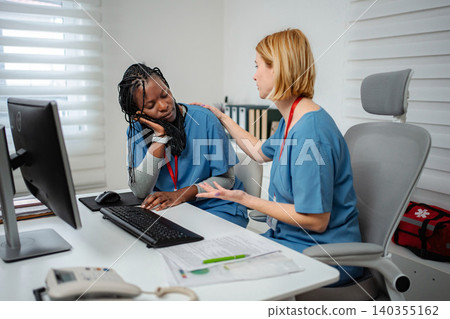 Nurse experiencing burnout feeling tired, coworker offering support Nurse experiencing burnout feeling tired, coworker offering support 140355162