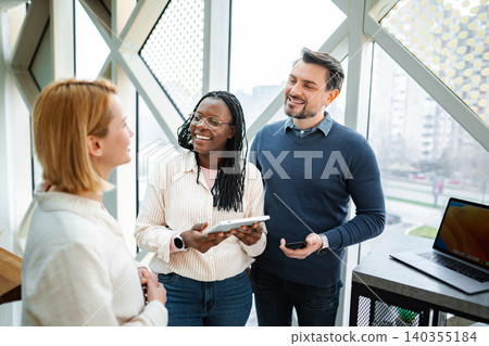 Diverse coworkers collaborating in office with digital tablet Diverse coworkers collaborating in office with digital tablet 140355184