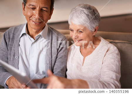 Senior, couple and happiness with tablet on couch for online bingo, crossword puzzle and internet games in living room. Elderly, man and woman with face or smile with technology for web news in home 140355196