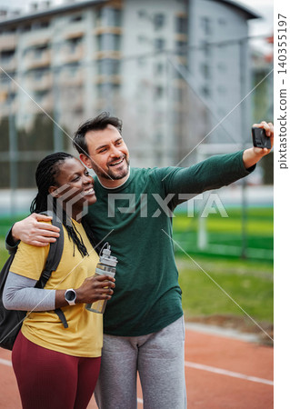 Diverse couple taking happy fitness selfie on track Diverse couple taking happy fitness selfie on track 140355197