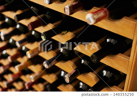 Wine cellar, bottle and storage on rack in basement for restaurant stock, winery and shelf with alcohol display. Warehouse, drinks collection and beverage stack in vineyard with arrangement and row Wine cellar, bottle and storage on rack in basement for restaurant stock, winery and shelf with alcohol display. Warehouse, drinks collection and beverage stack in vineyard with arrangement and row 140355250