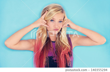 Model, portrait and punk style in studio mock up and devil horns gesture in rock fashion by blue background. California, young woman or face with attitude in trendy clothes or cool in gen z aesthetic 140355294