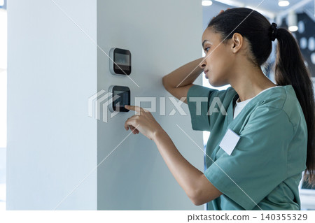 Tired after night shift doctor setting temperature on a climate control panel Tired after night shift doctor setting temperature on a climate control panel 140355329