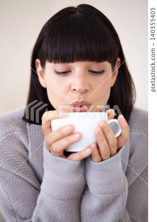Coffee, woman and blowing drink in home, calm and relax at breakfast for energy in the morning. Cool down, tea and person with hot espresso in cup, beverage and fresh cappuccino for health in house Coffee, woman and blowing drink in home, calm and relax at breakfast for energy in the morning. Cool down, tea and person with hot espresso in cup, beverage and fresh cappuccino for health in house 140355405