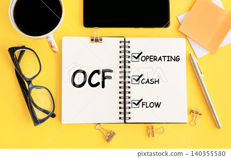 OCF text written on notepad on the yellow office background OCF text written on notepad on the yellow office background 140355580
