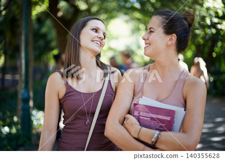 Students, friends and talking of education on campus with learning, knowledge and books at college. Happy women with outdoor conversation in a park or university for scholarship, study or opportunity Students, friends and talking of education on campus with learning, knowledge and books at college. Happy women with outdoor conversation in a park or university for scholarship, study or opportunity 140355628