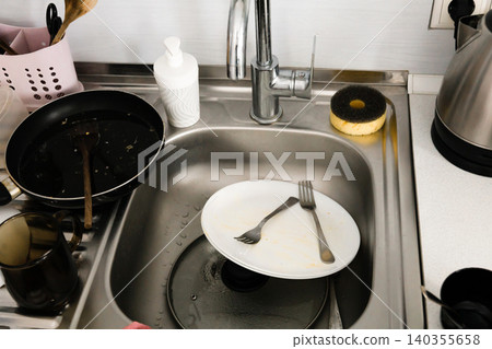 Dirty dishes in the sink prepared for washing Cleaning concept 140355658