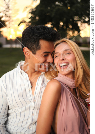 Joyful couple enjoying a sunset together in the park Joyful couple enjoying a sunset together in the park 140355697