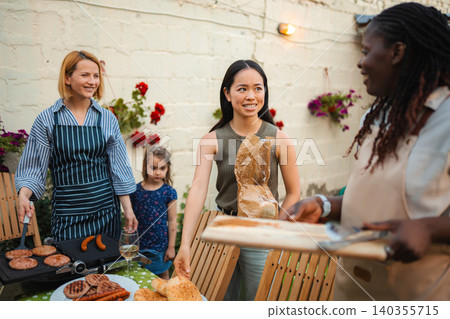 Multi-ethnic friends having backyard barbecue party together Multi-ethnic friends having backyard barbecue party together 140355715