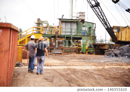 Crane, machine and engineer men in scrapyard to recycle metal for sustainability, manufacturing or pollution. Vehicle, people and outdoor in junkyard for ecology with back, industry and environment 140355820