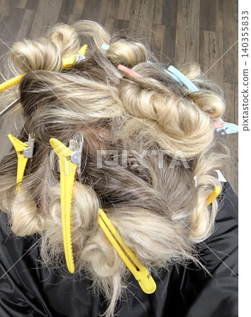 Top-down view of a hairstylist styling hair. 140355833
