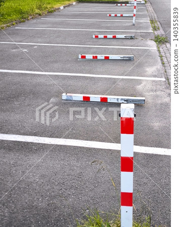 Empty parking lot with fold-down space barriers Empty parking lot with fold-down space barriers 140355839