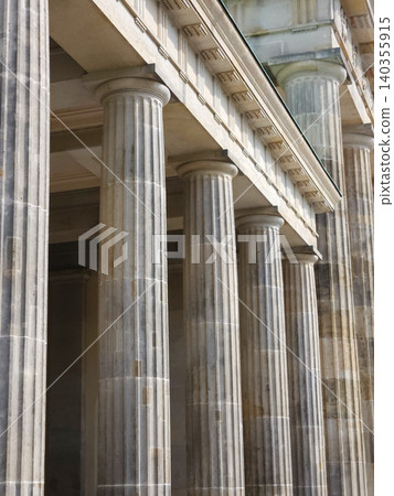 Classical stone columns stand along historic building facade Classical stone columns stand along historic building facade 140355915