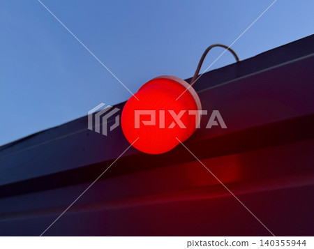Close-up red warning light glowing on construction fence at night, blurred industrial background with bokeh, work zone safety concept Close-up red warning light glowing on construction fence at night, blurred industrial background with bokeh, work zone safety concept 140355944