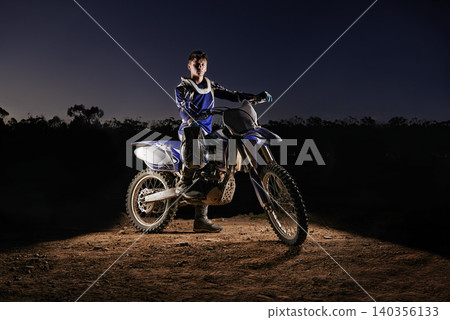 Extreme sport, portrait and man with dirt bike, confidence and gear for competition, race or challenge. Adventure, adrenaline and serious face of athlete on course with off road motorbike at night 140356133
