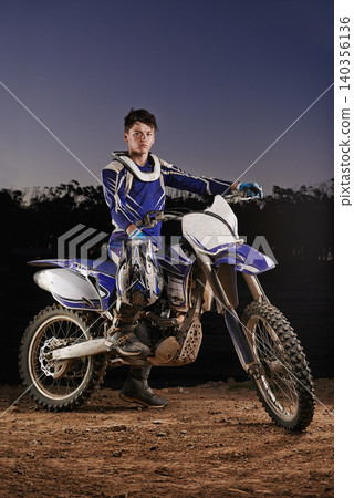 Extreme sport, portrait and man with off road motorbike, confidence and gear for competition, race or challenge. Adventure, adrenaline and serious face of athlete on course with dirt bike at night Extreme sport, portrait and man with off road motorbike, confidence and gear for competition, race or challenge. Adventure, adrenaline and serious face of athlete on course with dirt bike at night 140356136