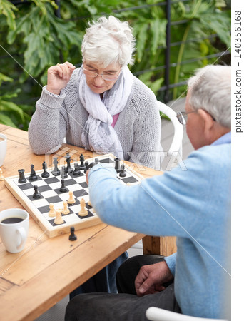Chess, strategy and senior couple thinking while playing a board game in the backyard or bonding together. Mind, relax or challenge with an elderly man or old woman in the garden for hobby and coffee Chess, strategy and senior couple thinking while playing a board game in the backyard or bonding together. Mind, relax or challenge with an elderly man or old woman in the garden for hobby and coffee 140356168