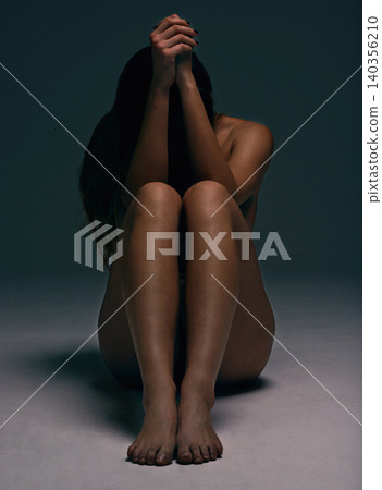 Naked, body and woman on floor in studio for creative aesthetic, art deco and skin texture. Shadow, dark background and nude person sitting and covering face for wellness, sensuality and beauty Naked, body and woman on floor in studio for creative aesthetic, art deco and skin texture. Shadow, dark background and nude person sitting and covering face for wellness, sensuality and beauty 140356210