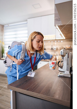 Nurse preparing coffee before work in the kitchen Nurse preparing coffee before work in the kitchen 140356215