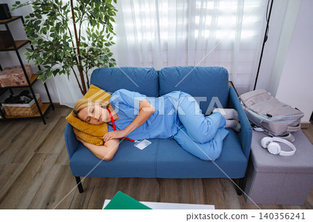 Exhausted Female Doctor Sleeping on Couch After Work 140356241