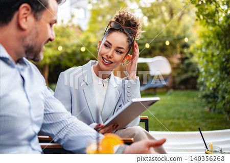Successful business woman holding tablet talking with colleague outdoors 140356268