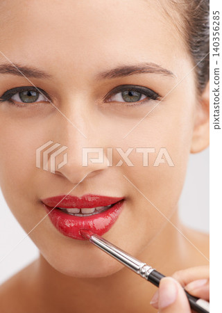 Happy woman, portrait and red lipstick with makeup for beauty or facial cosmetics on a white studio background. Face or closeup of female person or model applying color, gloss or glow for cosmetology Happy woman, portrait and red lipstick with makeup for beauty or facial cosmetics on a white studio background. Face or closeup of female person or model applying color, gloss or glow for cosmetology 140356285