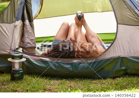 Camping, selfie and friends in tent with camera for memory of vacation and relax together. Back, head and girls capture photography with tech on holiday, adventure or casual moment outdoor in summer 140356422