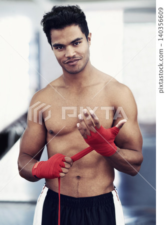 Athlete, portrait and smile for MMA in gym for training, wellness and sport with workout for body. Man, exercise and wraps on hands, muscle and health for person in fitness centre and strong Athlete, portrait and smile for MMA in gym for training, wellness and sport with workout for body. Man, exercise and wraps on hands, muscle and health for person in fitness centre and strong 140356609