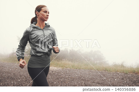 Fog, fitness and woman running on road outdoor for healthy body, wellness and training for sports on mockup space in winter. Mist, exercise and person workout for cardio, race and energy in nature Fog, fitness and woman running on road outdoor for healthy body, wellness and training for sports on mockup space in winter. Mist, exercise and person workout for cardio, race and energy in nature 140356886