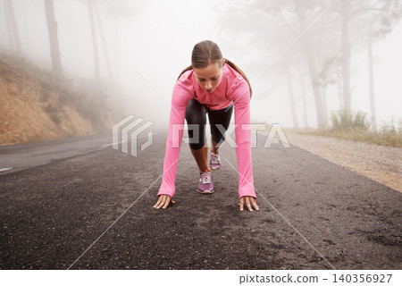 Runner, start and woman on path outdoor in forest, park or woods for exercise in winter. Morning, fog and person with fitness challenge or prepare for workout on road in countryside with nature Runner, start and woman on path outdoor in forest, park or woods for exercise in winter. Morning, fog and person with fitness challenge or prepare for workout on road in countryside with nature 140356927