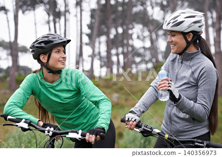 Cycling, fitness and friends in nature talking of training, race or journey with break and stop in the forest. Happy women or people drinking water, bicycle and conversation for exercise and teamwork 140356973